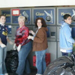 people recycling and smiling at camera