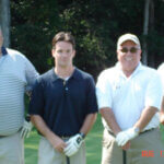 mens holding golf clubs and smiling for photo