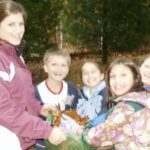 children picking up leaves and smiling