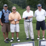 Men with golf clubs posing for picture