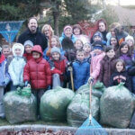 Hauppauge students racking leaves and smiling for photo