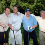 golfers holding clubs and posing for picture