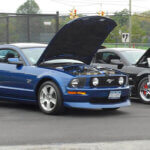 cars in car show with trophies near them