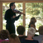 violinist playing in front of group of people