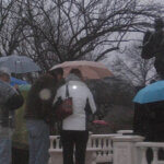 people gathered near Angle of Hope statue at candle lit vigil