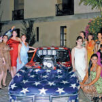 women near car that is painted as american flag